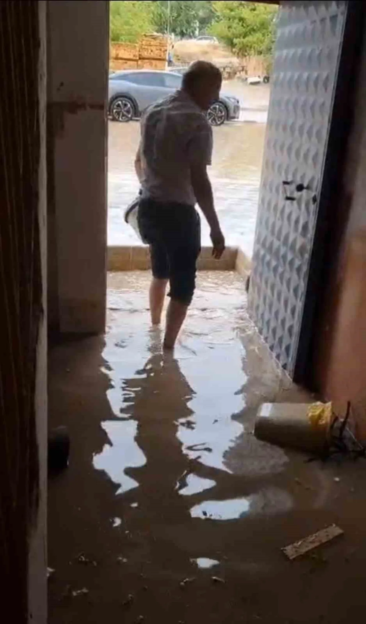 BİNA GİRİŞ KATINI SU KOVALARI İLE BOŞALTAN VATANDAŞ