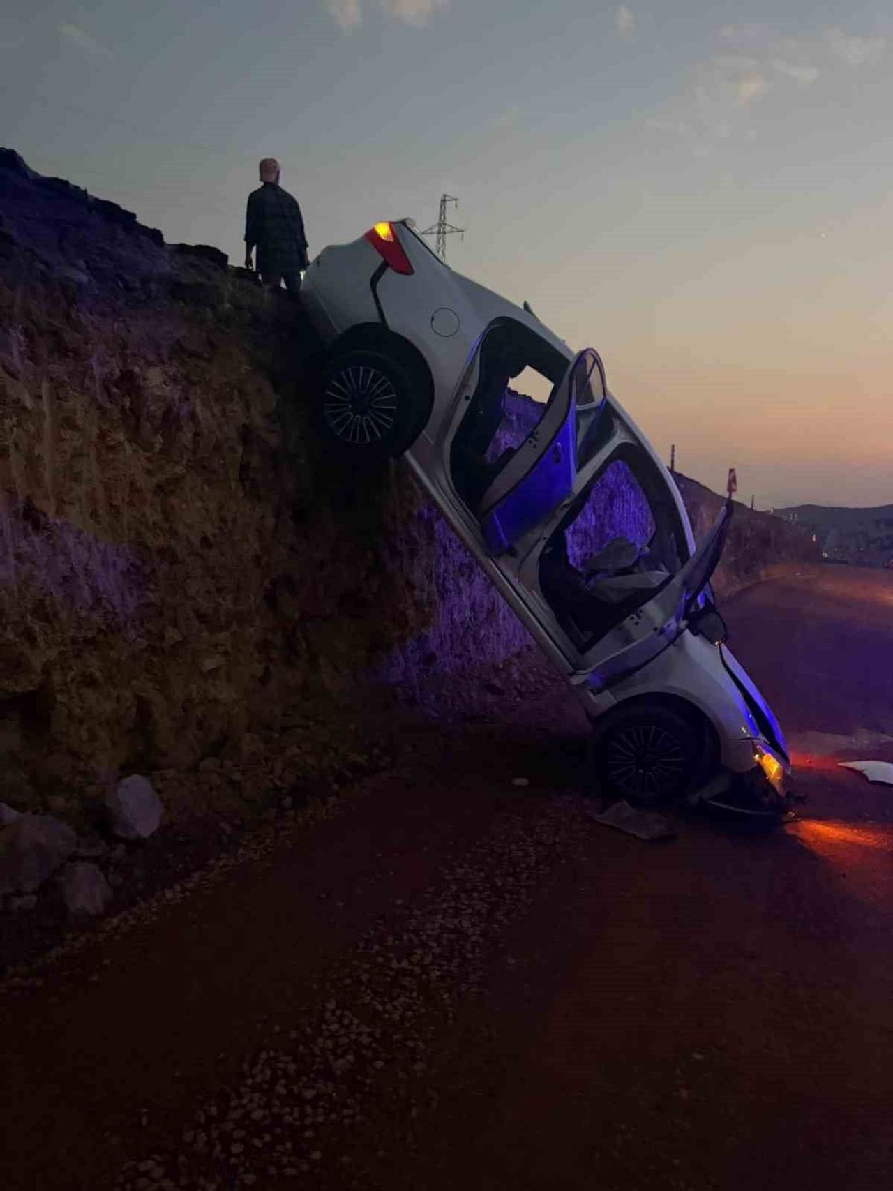 KAZILAN YOLA DÜŞEN OTOMOBİL ASKIDA KALDI: 2 YARALI