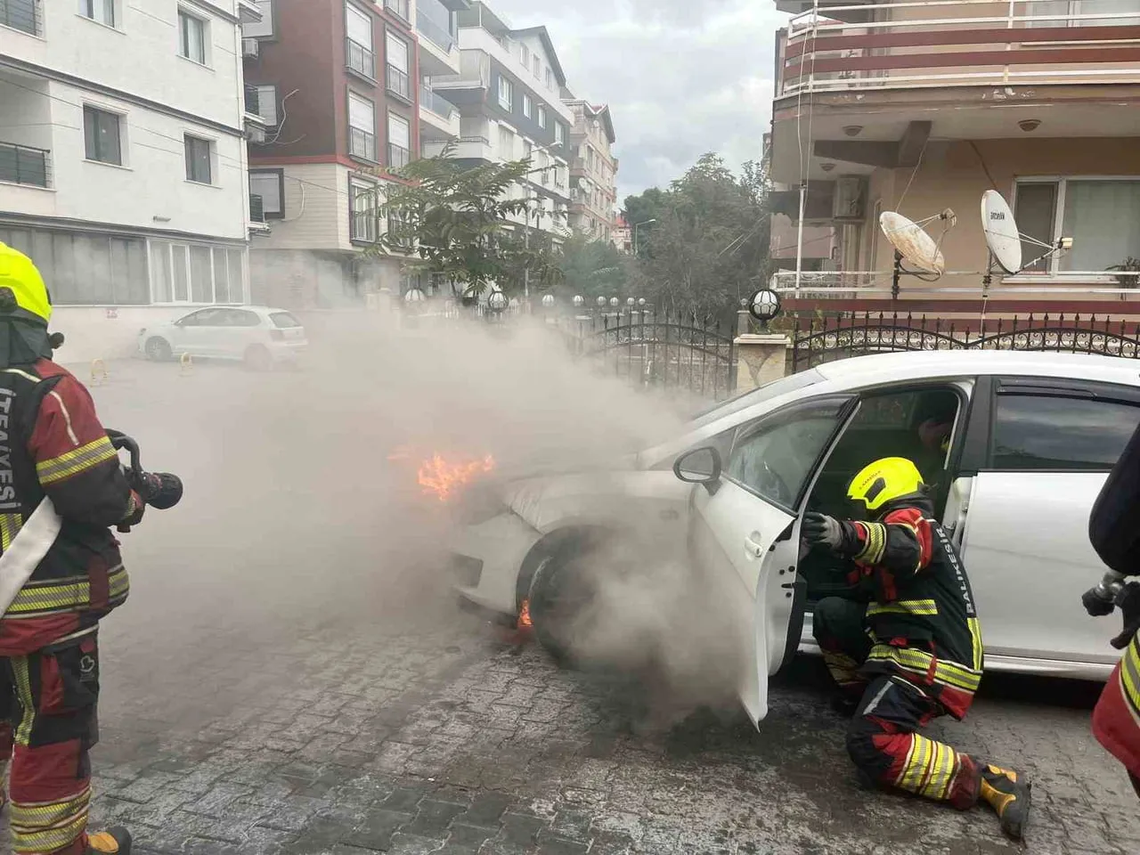 BALIKESİR’İN BURHANİYE İLÇESİNDE CADDE ÜZERİNDE ANİDEN ALEV ALAN OTOMOBİL, İTFAİYE EKİPLERİNİN...