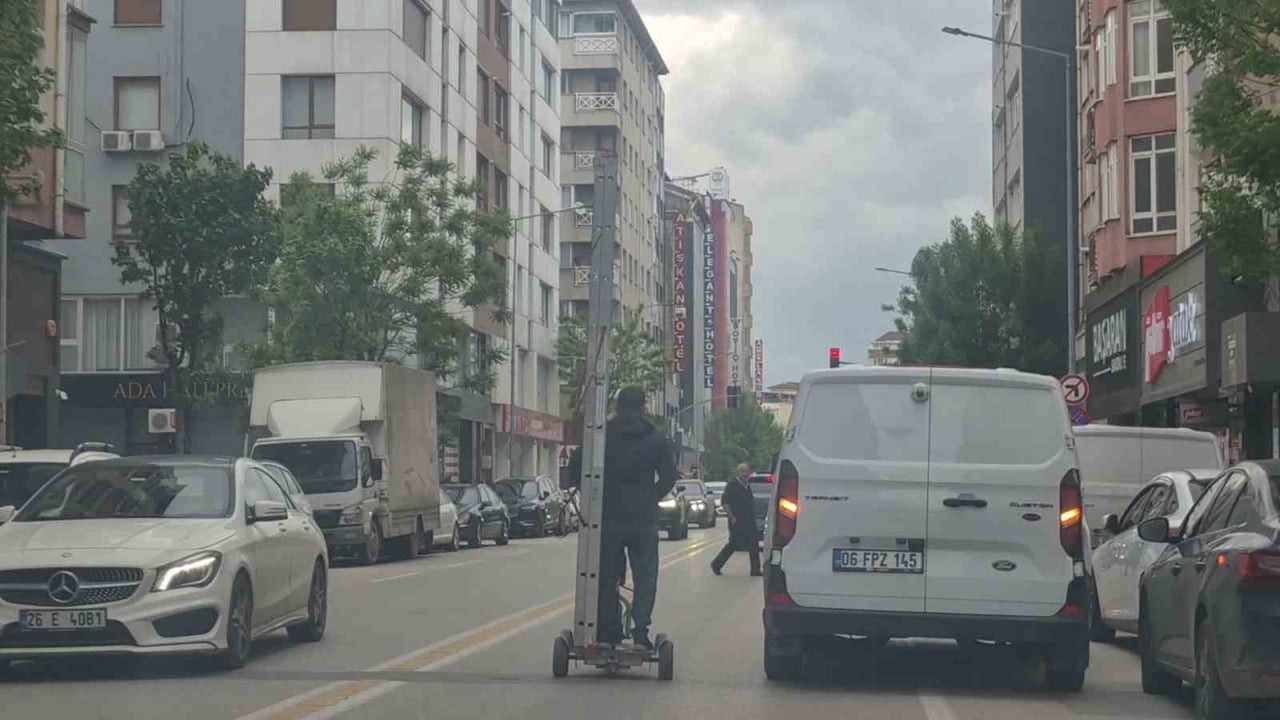 ESKİŞEHİR'DE BİR VATANDAŞ KENDİ BOYUNDAN UZUN MERDİVENİ TRAFİK AKIŞININ DEVAM ETTİĞİ BİR CADDE DE...