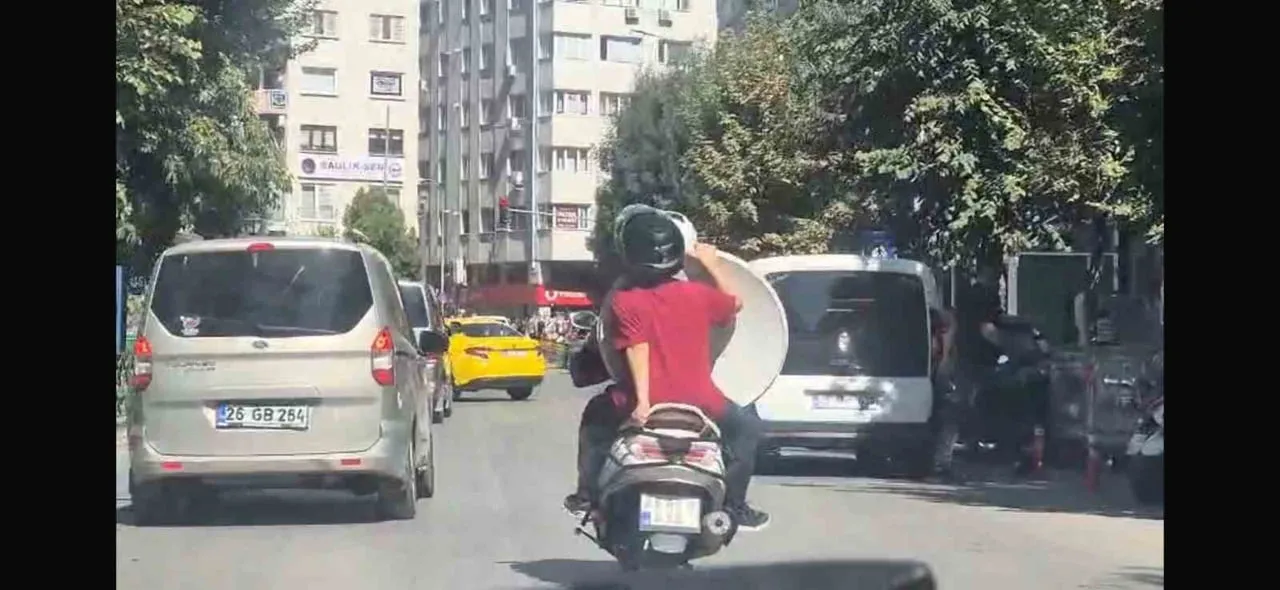 ESKİŞEHİR’İN İŞLEK CADDELERİNDEN BİRİNDE MOTOSİKLET SÜRÜCÜSÜNÜN ARKASINDAKİ YOLCUNUN, TRAFİKTE...