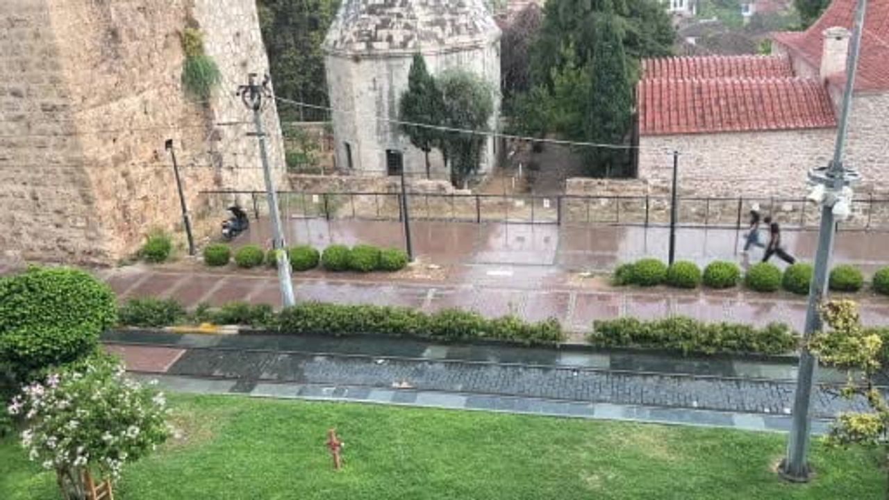 Antalya'da aniden bastıran yağmur, tatilcilere temmuz ayında şemsiye açtırdı