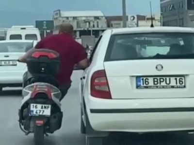 Bursa'da bir motosiklet sürücüsü arkadaşının otomobiline yaslanarak ilerledi! O anlar kameraya yansıdı