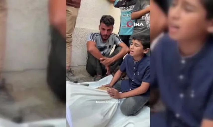 Gazze'de bir çocuk kuzeninin başında gözyaşlarıyla Kur'an okudu