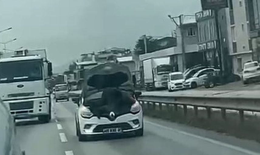 Bursa'da otomobilin hareket halindeyken kaputunu açarak tamir eden tamirci dikkat çekti